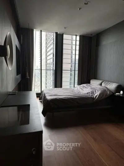 Modern bedroom with floor-to-ceiling windows and sleek design in urban apartment.