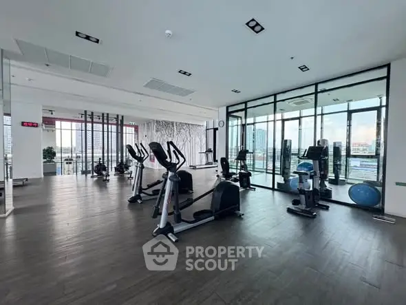 Spacious modern gym with city view and state-of-the-art equipment.