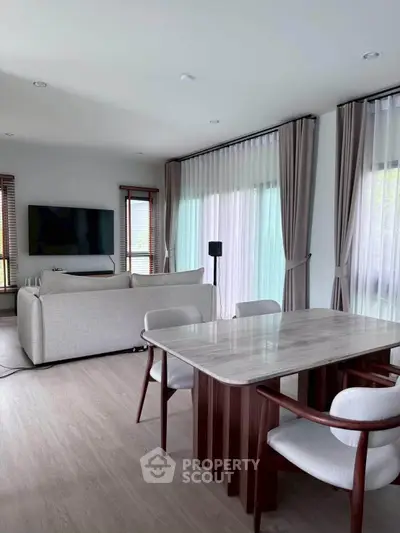 Modern living room with elegant dining area and large windows