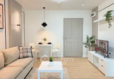 Modern living room with cozy sofa, stylish decor, and dining area in open layout apartment.