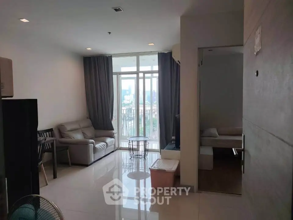 Spacious living room with modern furniture and large windows offering city views.