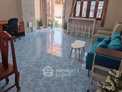 Spacious living room with blue patterned tiles, modern furniture, and natural light.