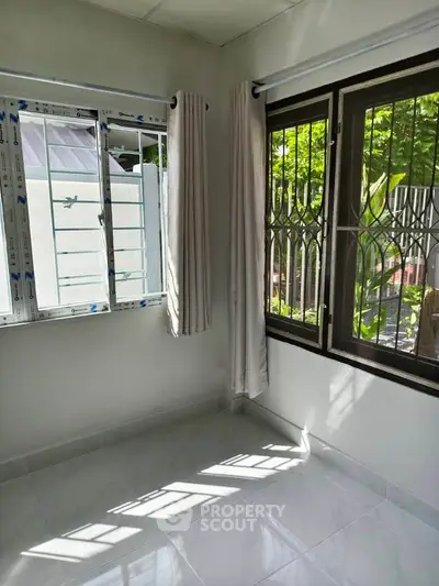 Bright corner room with large windows and garden view, perfect for natural light lovers.