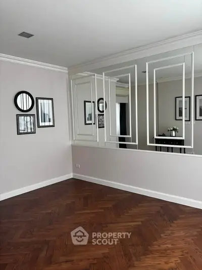 Elegant interior with parquet flooring and decorative wall mirrors in a modern living space.