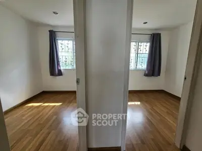 Spacious dual-bedroom layout with wooden flooring and ample natural light.