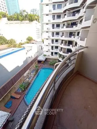 Stunning balcony view overlooking a luxurious pool in a modern apartment complex.