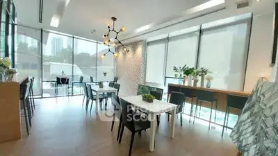 Modern dining area with stylish lighting and large windows in a contemporary apartment.