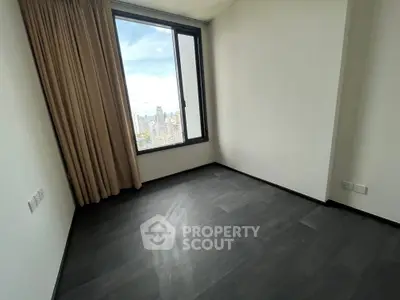 Spacious empty room with large window offering stunning city view, perfect for customization.