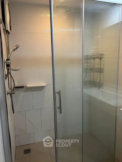 Modern bathroom with glass shower enclosure and sleek fixtures.
