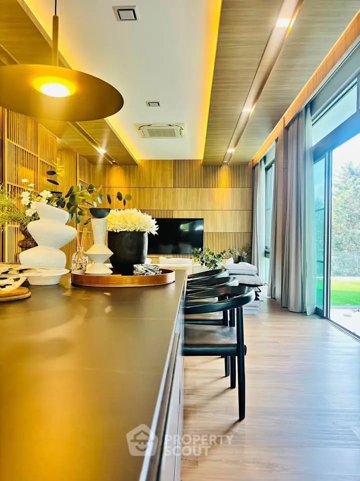 Luxurious modern living room with elegant decor and large windows overlooking a lush garden.