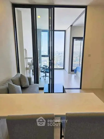 Modern apartment interior with open layout, featuring a cozy living area and a stunning city view.