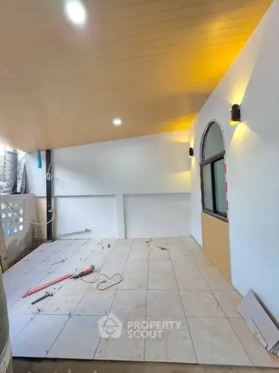 Spacious under-construction balcony with modern lighting and tiled flooring.