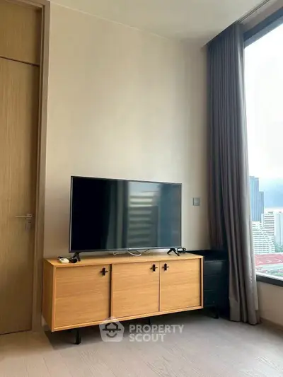 Modern living room with sleek TV stand and city view window