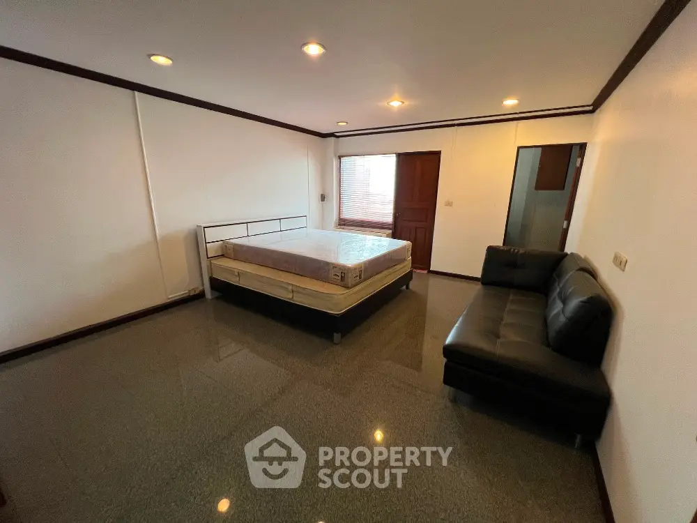 Spacious bedroom with modern furnishings and ample natural light