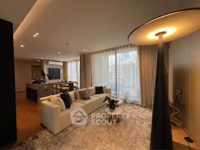 Luxurious modern living room with elegant decor and large windows offering natural light.