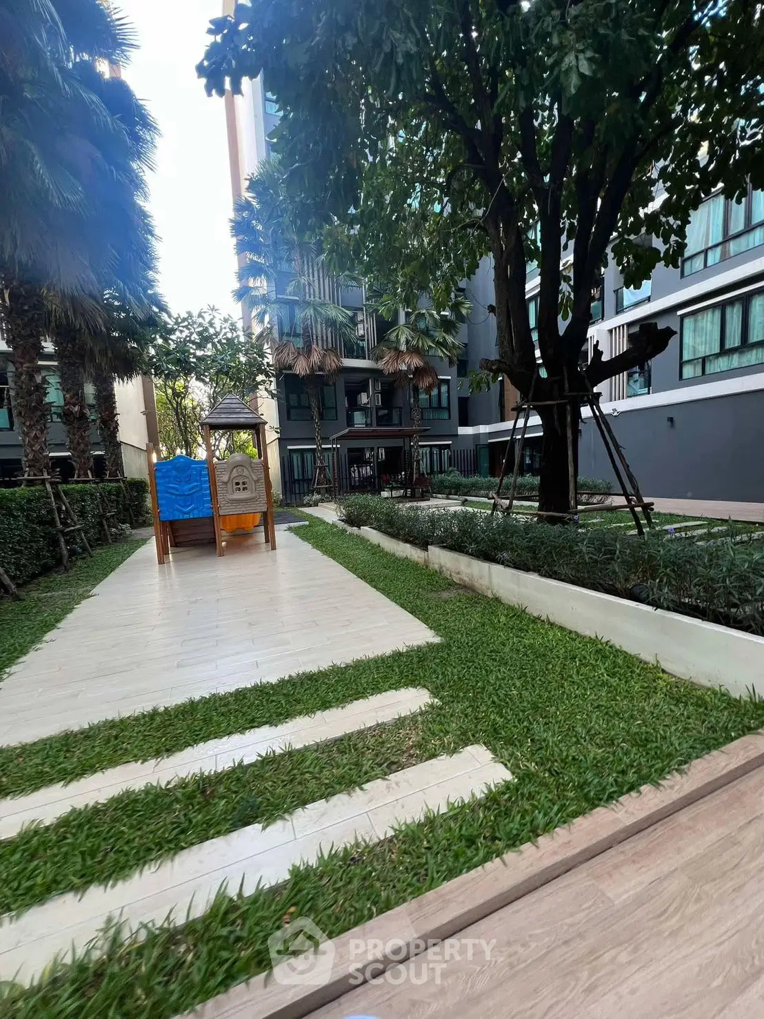 Modern apartment building with lush garden and play area, perfect for families seeking urban tranquility.