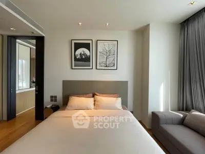 Modern bedroom with stylish decor and natural light, featuring a cozy bed and elegant artwork.