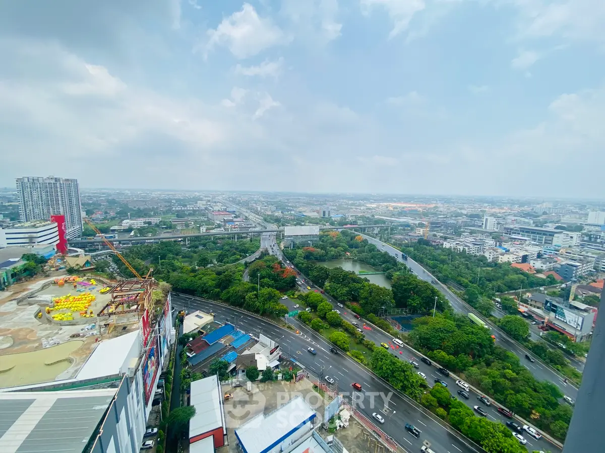 Stunning panoramic cityscape view from a high-rise building, showcasing urban and green landscapes.