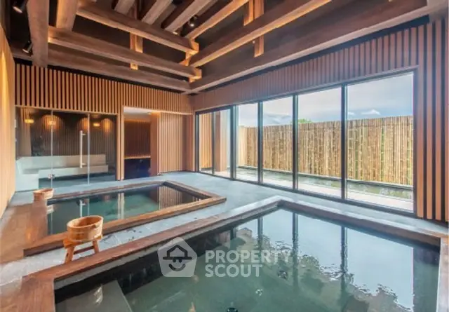 Luxurious indoor pool with wooden accents and large windows offering serene views.