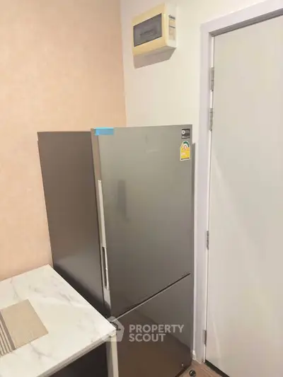 Modern kitchen corner with sleek refrigerator and marble countertop