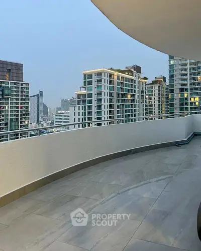 Spacious balcony with stunning cityscape views in modern high-rise building.