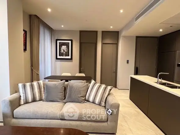 Modern open-plan living room with stylish kitchen and cozy sofa.