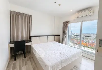 Bright bedroom with balcony and city view, featuring modern furniture and air conditioning.
