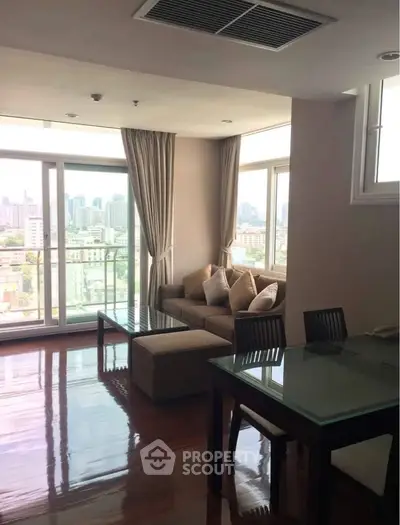 Spacious living room with city view and elegant furnishings in a modern apartment.