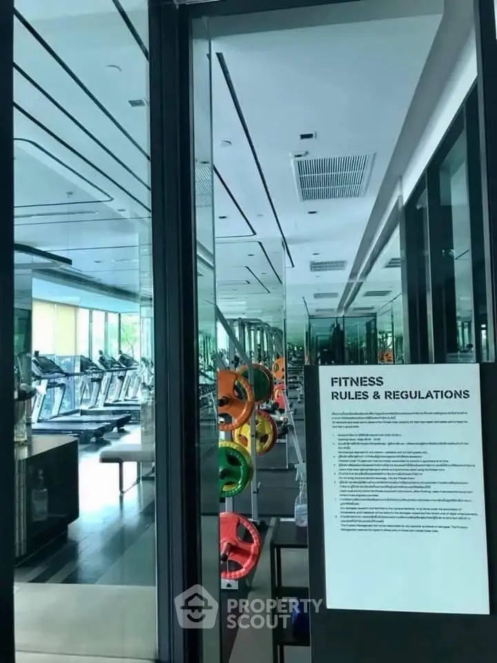 Modern gym with fitness equipment and mirrored walls in luxury building