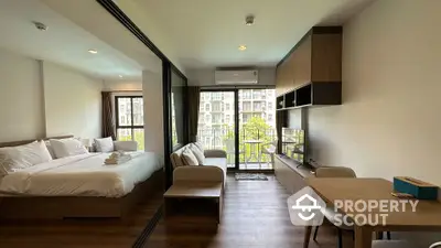 Modern studio apartment with cozy bedroom and living area, featuring a balcony with a view.