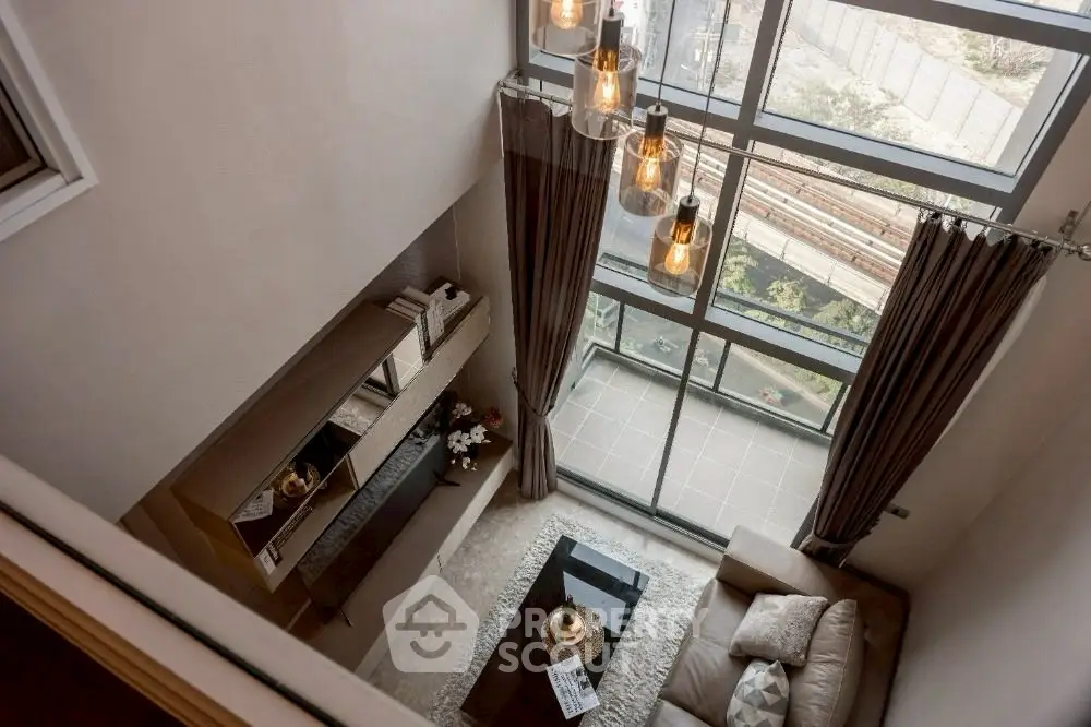 Luxurious loft-style living room with floor-to-ceiling windows and elegant decor.
