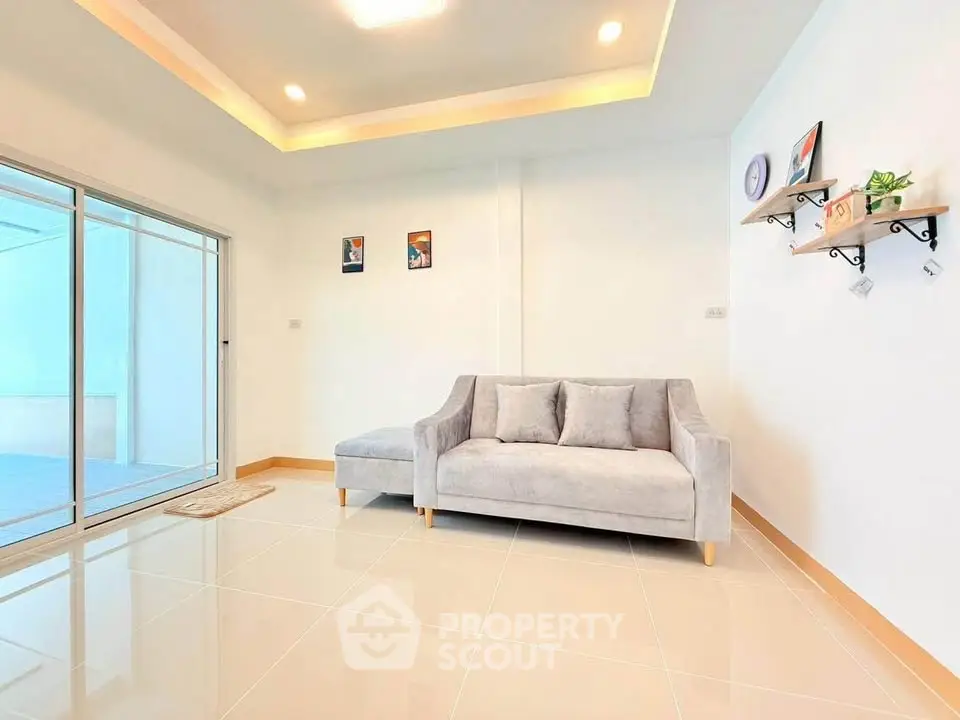 Modern living room with sleek sofa and sliding glass doors to balcony