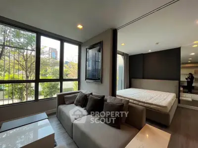 Modern studio apartment with large windows and stylish furnishings