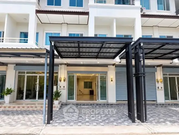 Modern townhouse exterior with covered parking and large glass doors.