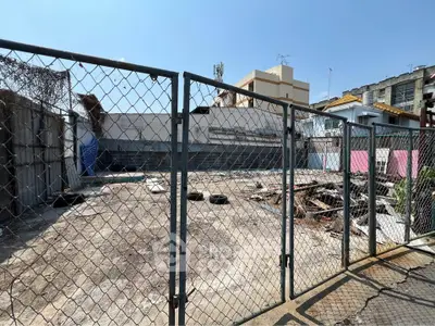 Vacant urban lot with chain-link fence, ideal for development opportunities.