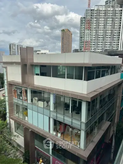Modern multi-story building with glass facade and city skyline view