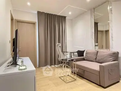 Modern living room with sleek furniture and neutral tones, featuring a cozy sofa and stylish decor.