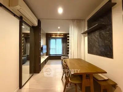 Modern living room with dining area, featuring sleek furniture and ambient lighting.