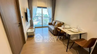 Modern living room with balcony view, stylish furniture, and dining area in a cozy apartment.