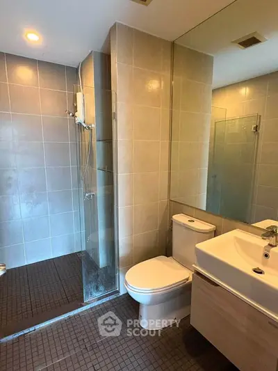 Modern bathroom with glass shower and sleek fixtures in a contemporary apartment.
