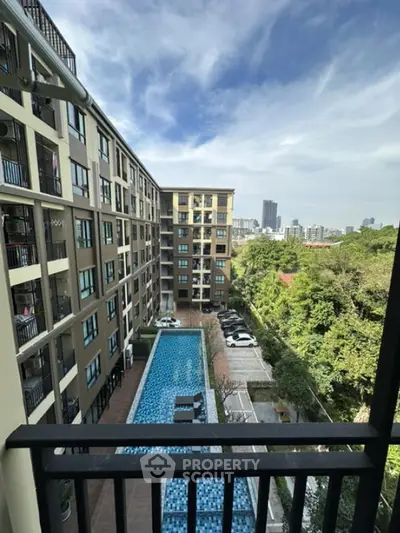 Modern apartment building with pool and city view from balcony