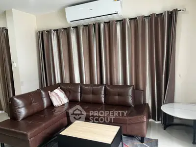 Modern living room with brown leather sectional sofa and elegant curtains
