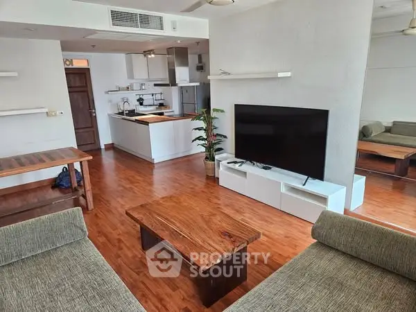 Spacious living room with modern open kitchen and wooden flooring