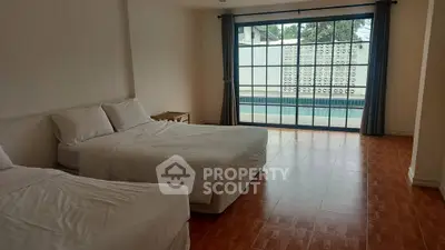 Spacious bedroom with pool view and large windows for natural light