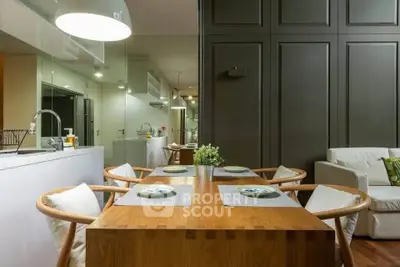 Modern dining area with wooden table and stylish chairs in open-plan kitchen and living room.