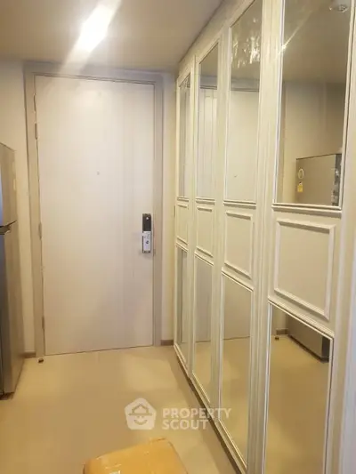 Modern apartment entrance with mirrored closet and digital lock