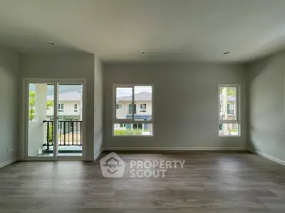 Spacious empty living room with large windows and balcony view