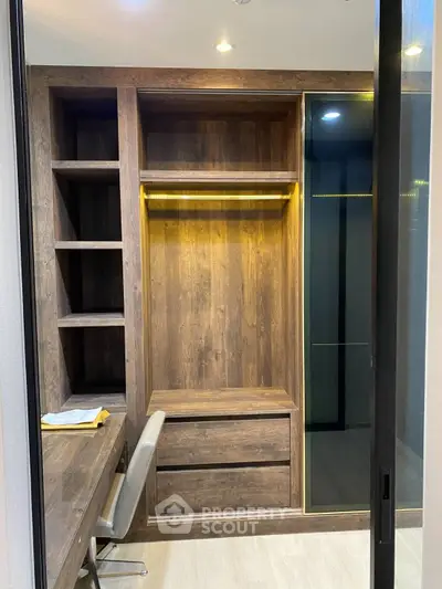 Modern study room with built-in wooden shelves and desk, featuring elegant lighting.