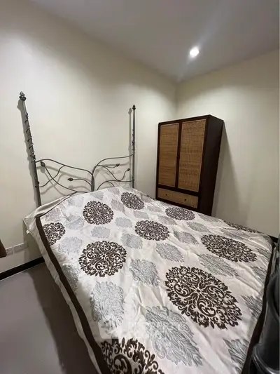 Cozy bedroom with elegant bed frame and stylish wardrobe, perfect for a restful retreat.