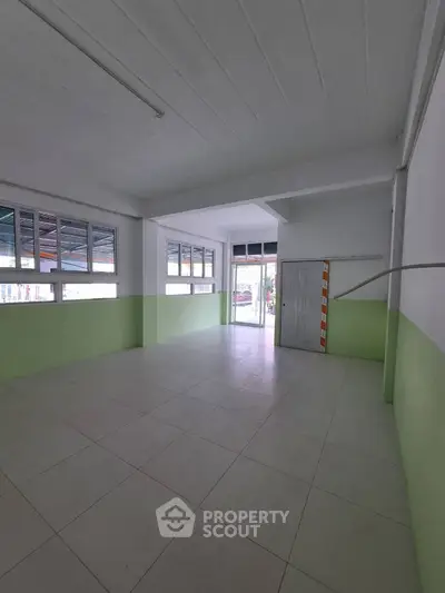 Spacious empty room with large windows and tiled floor, ideal for customization.